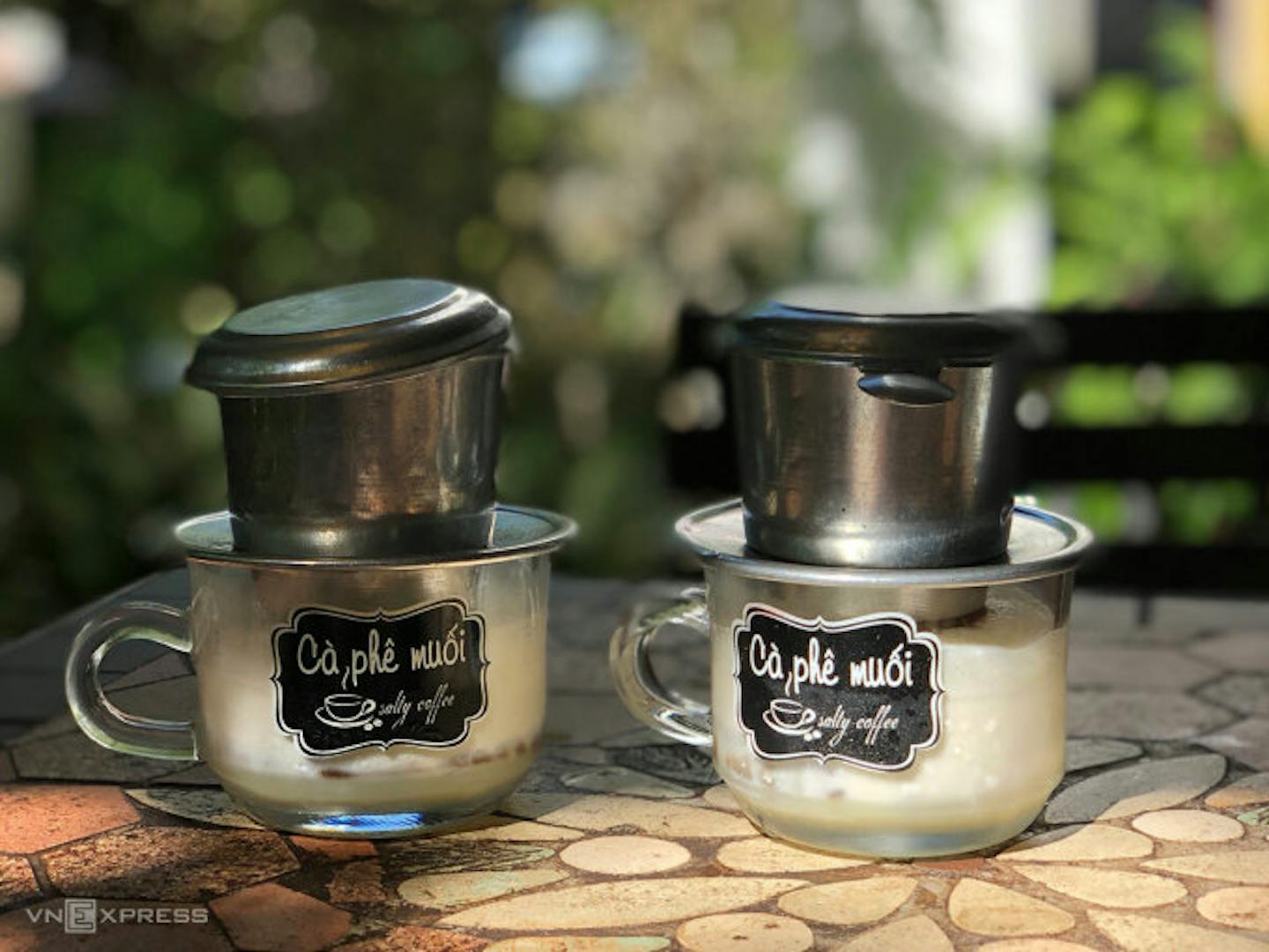 Two cups of salt coffee placed on a stone table.